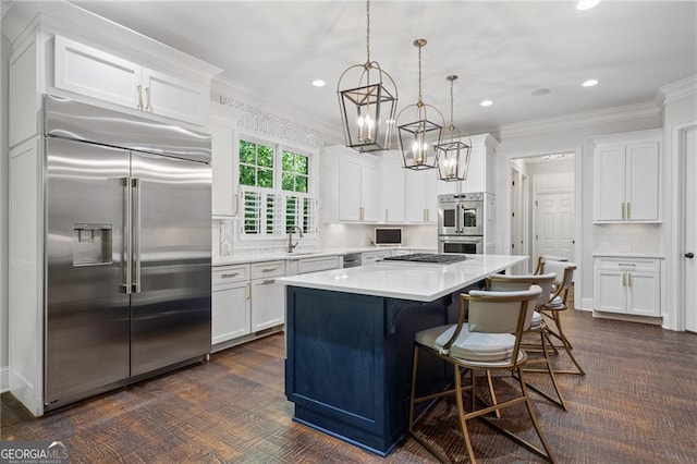 kitchen featuring a center island, appliances with stainless steel finishes, hanging light fixtures, and white cabinets