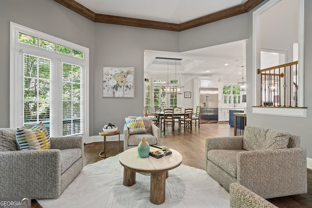 living room with a high ceiling, a notable chandelier, and hardwood / wood-style flooring