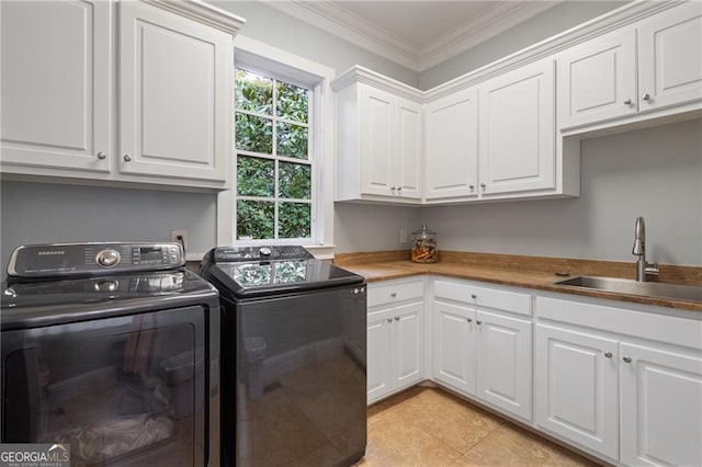 laundry area featuring washer and clothes dryer, ornamental molding, sink, light tile patterned floors, and cabinets