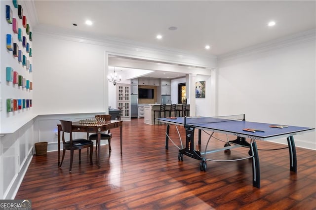 game room with crown molding, a notable chandelier, and dark hardwood / wood-style flooring