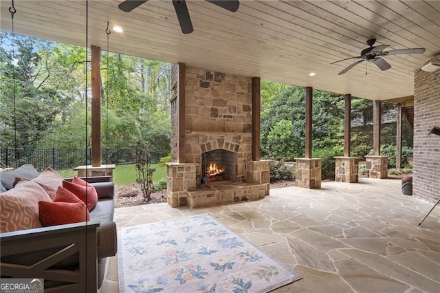 view of patio / terrace with ceiling fan and an outdoor stone fireplace