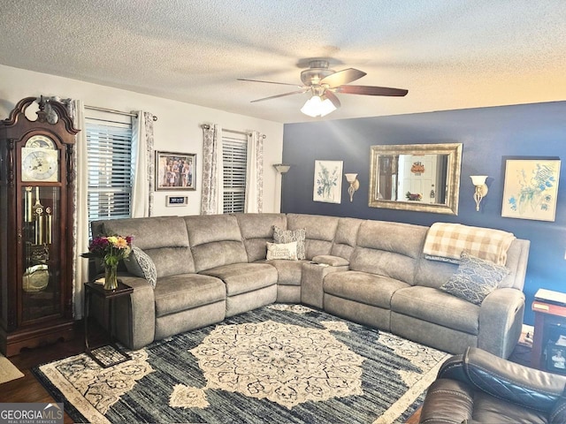 living room with dark hardwood / wood-style flooring, a textured ceiling, and ceiling fan