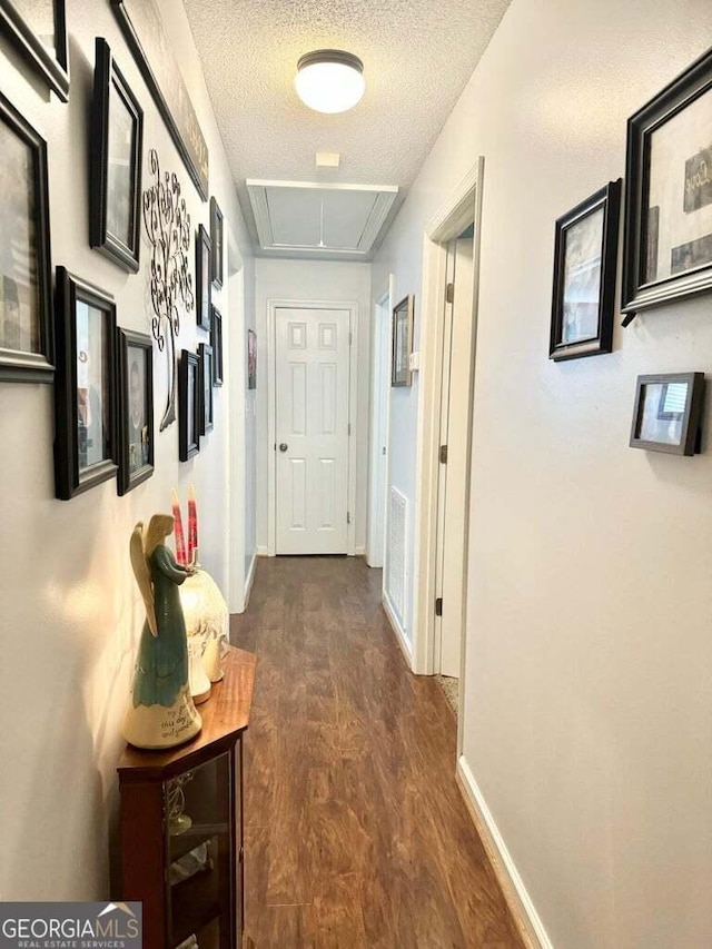 hall with dark hardwood / wood-style floors and a textured ceiling