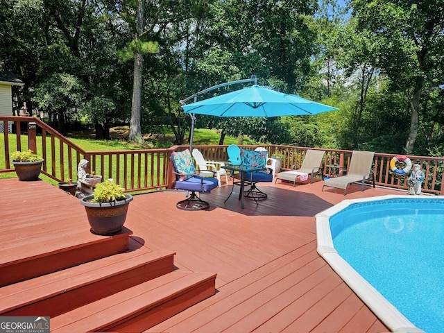 view of swimming pool featuring a deck and a lawn