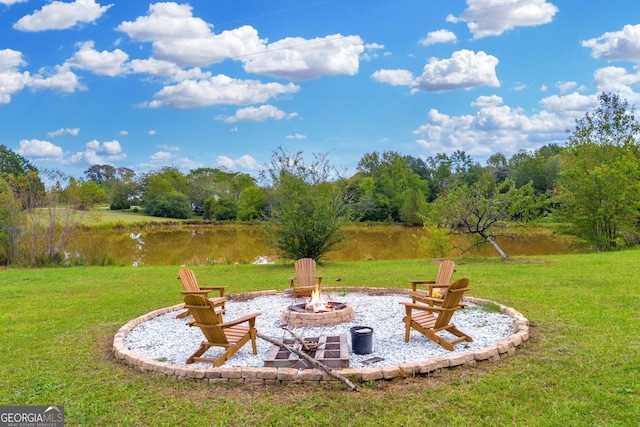 view of yard with a fire pit and a water view