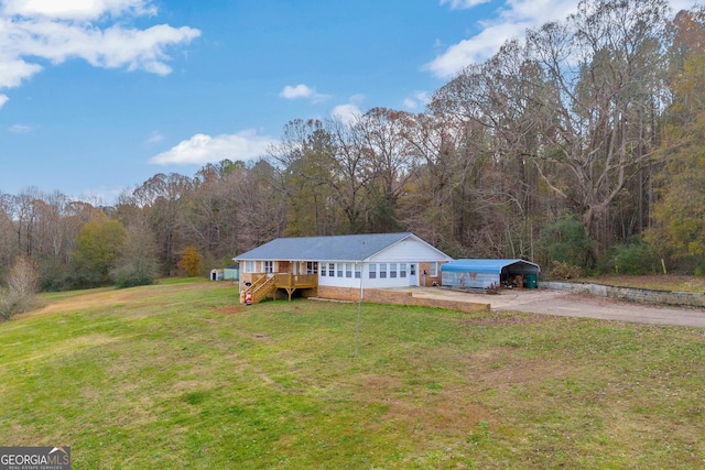 ranch-style home featuring a deck, a front yard, and a carport