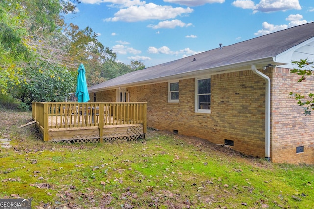 back of house featuring a deck and a lawn