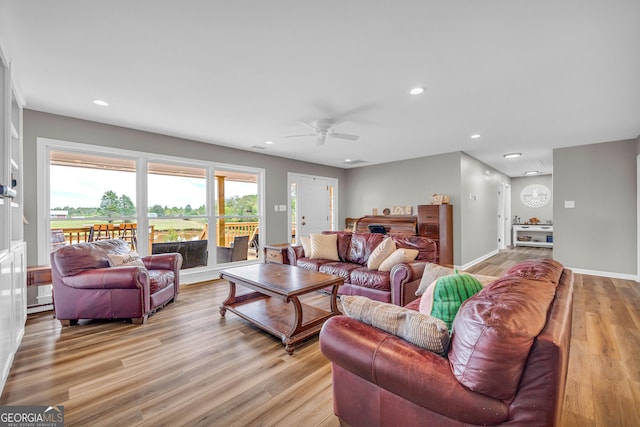 living room with light wood-type flooring and ceiling fan