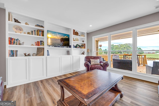 living area featuring built in features and light wood-type flooring