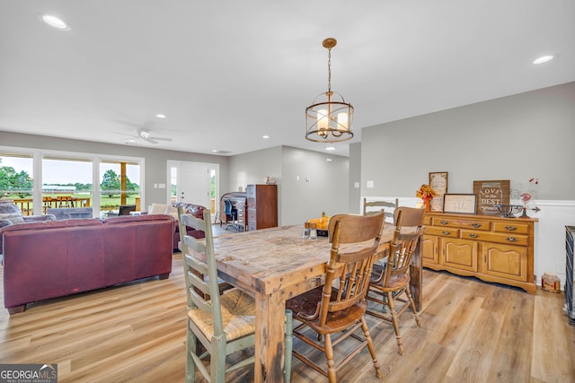 dining room featuring light hardwood / wood-style flooring and ceiling fan with notable chandelier