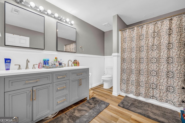 bathroom with hardwood / wood-style floors, vanity, and toilet