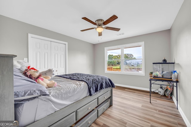 bedroom featuring a closet, light hardwood / wood-style flooring, and ceiling fan