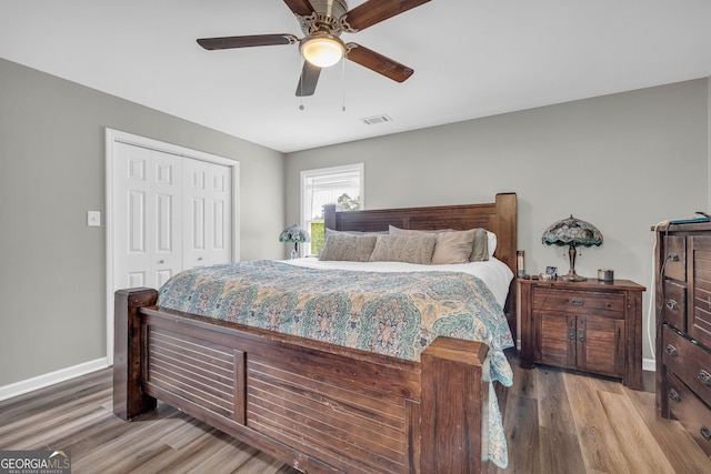 bedroom featuring ceiling fan, wood-type flooring, and a closet