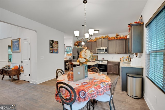 dining area featuring a notable chandelier, light wood-type flooring, and sink