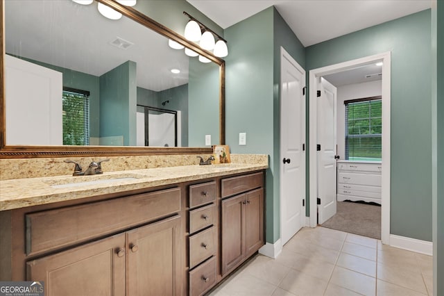 bathroom featuring vanity, a shower with shower door, and tile patterned flooring