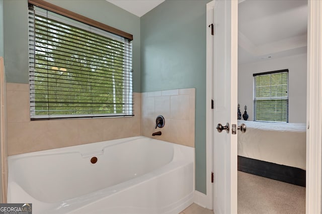 bathroom with crown molding, a bath, and a healthy amount of sunlight