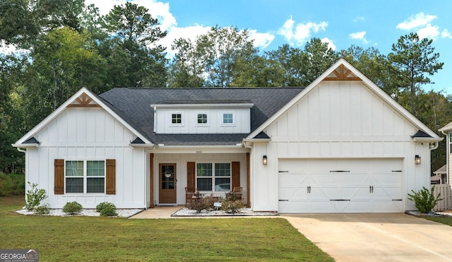 view of front facade with covered porch, a front yard, and a garage