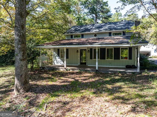 view of front of home featuring a porch and a shed