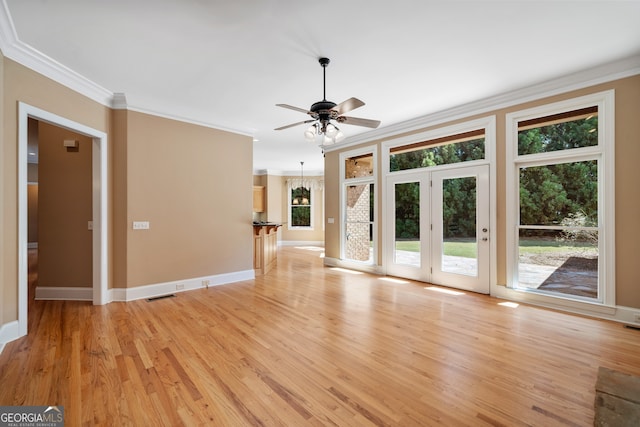 unfurnished living room with light wood-type flooring, ornamental molding, and ceiling fan