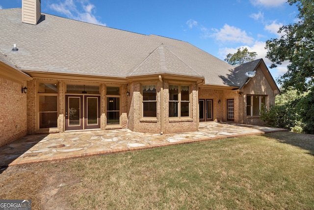 back of property with a patio and a yard