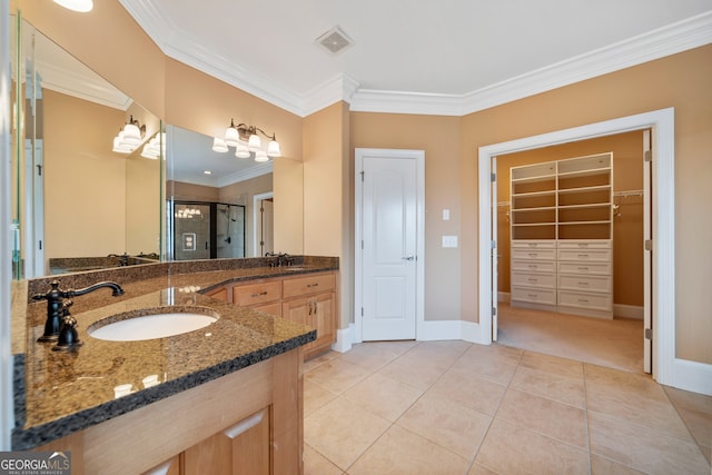 bathroom featuring tile patterned floors, a shower with door, vanity, and crown molding