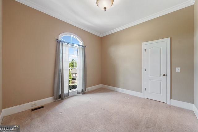 unfurnished room featuring light carpet, crown molding, and a healthy amount of sunlight