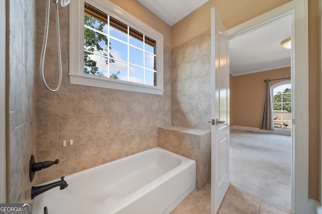 bathroom featuring a healthy amount of sunlight, crown molding, tiled shower / bath, and tile patterned floors