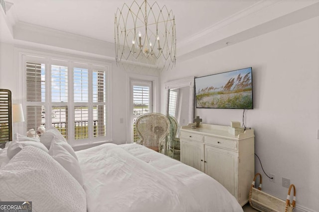 bedroom featuring a tray ceiling, crown molding, and a chandelier