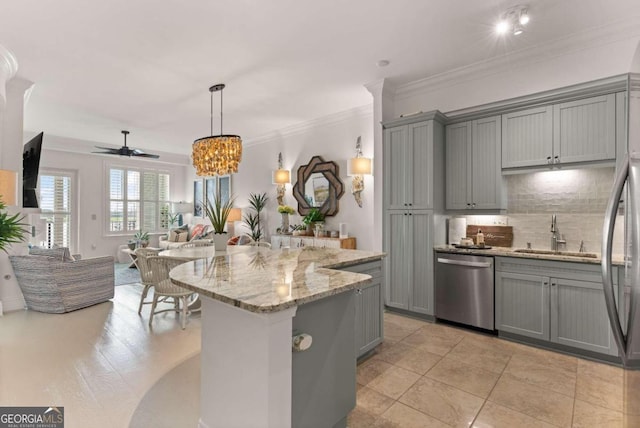 kitchen featuring light stone counters, pendant lighting, sink, gray cabinetry, and appliances with stainless steel finishes