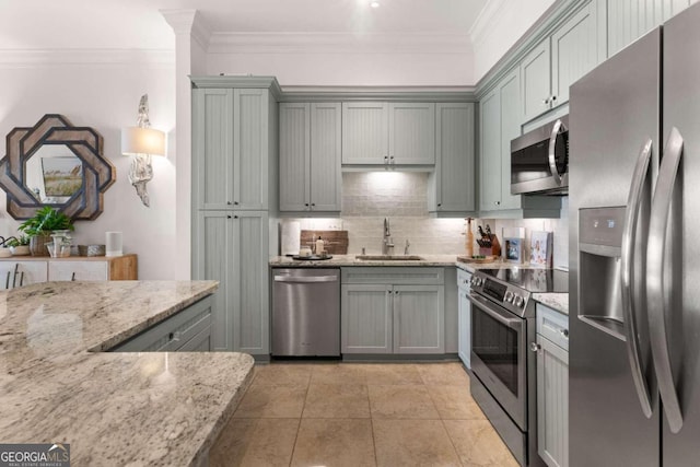 kitchen featuring light stone counters, light tile patterned flooring, sink, stainless steel appliances, and crown molding