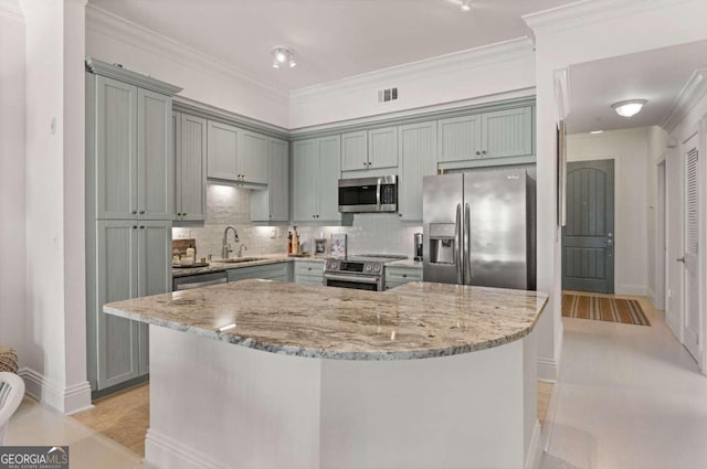 kitchen featuring crown molding, stainless steel appliances, and light stone counters