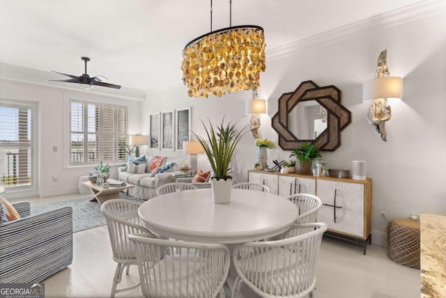 dining area featuring crown molding and ceiling fan with notable chandelier