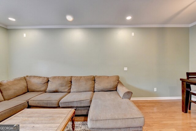 living room with wood-type flooring and ornamental molding