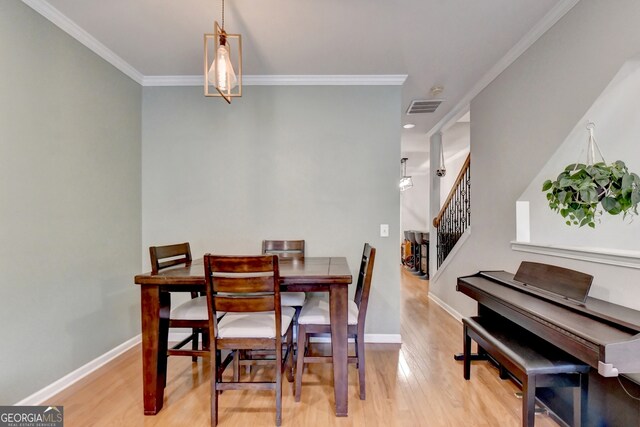 dining space featuring light hardwood / wood-style floors and ornamental molding