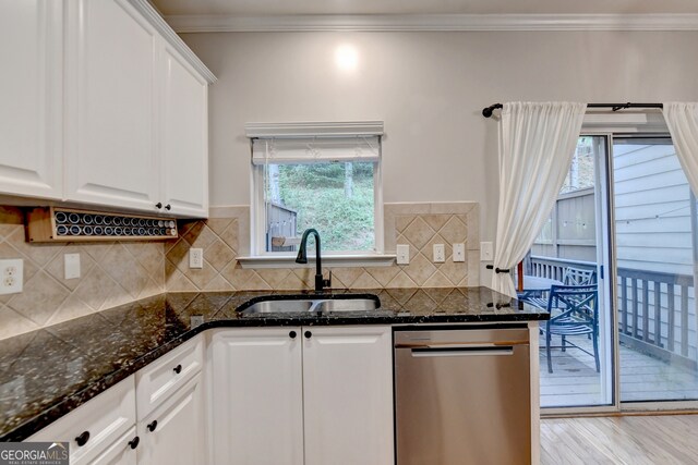 kitchen with dishwasher, sink, white cabinets, light hardwood / wood-style flooring, and dark stone countertops