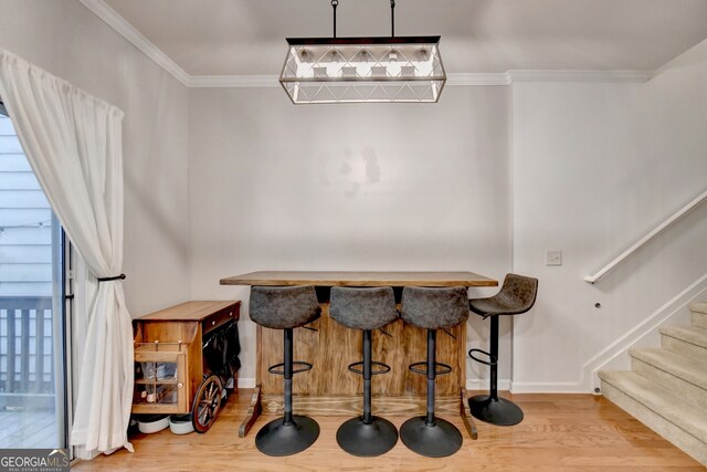 dining space featuring ornamental molding and hardwood / wood-style flooring