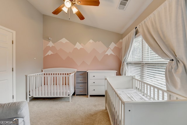 carpeted bedroom with lofted ceiling, ceiling fan, and a nursery area