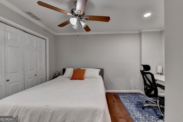 bedroom featuring ornamental molding, a closet, ceiling fan, and dark hardwood / wood-style floors