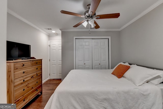 bedroom with ornamental molding, dark hardwood / wood-style flooring, ceiling fan, and a closet