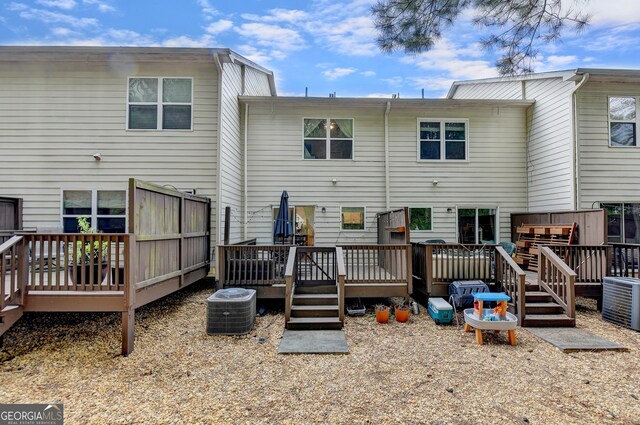 rear view of house with a wooden deck and cooling unit