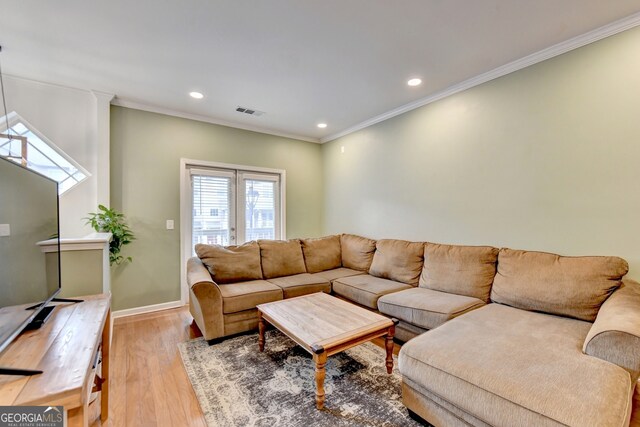 living room with crown molding and light hardwood / wood-style floors