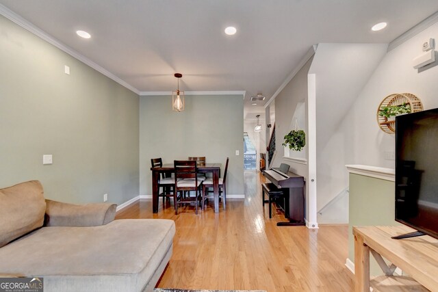 living room with light wood-type flooring and crown molding