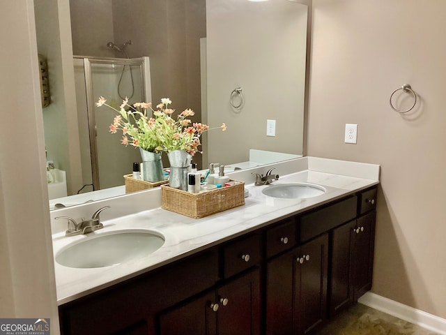 bathroom featuring a shower with door and vanity