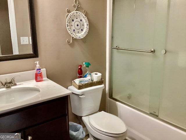 full bathroom featuring combined bath / shower with glass door, vanity, and toilet