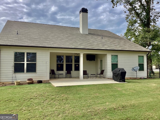 rear view of property with a lawn and a patio area