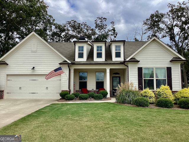 view of front of house featuring a front lawn, covered porch, and a garage