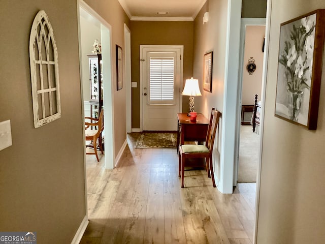 corridor featuring crown molding and light hardwood / wood-style floors