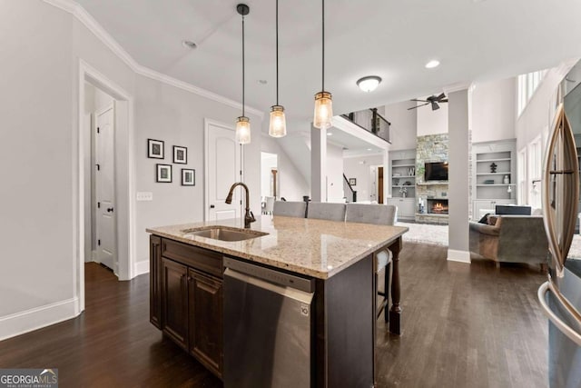 kitchen featuring appliances with stainless steel finishes, a kitchen breakfast bar, dark wood-type flooring, sink, and an island with sink