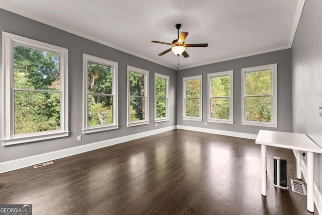 unfurnished living room with a wealth of natural light, crown molding, ceiling fan, and dark wood-type flooring