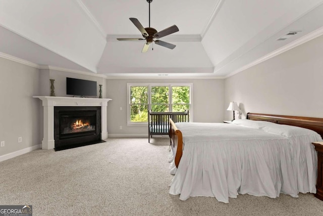 carpeted bedroom featuring ceiling fan, a raised ceiling, ornamental molding, and vaulted ceiling